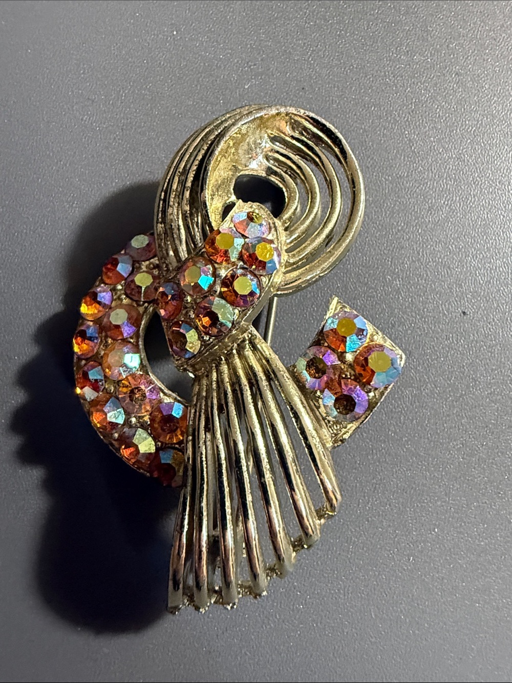 vintage gold-toned brooch featuring a swirling design  w/ AB crystal rhinestones